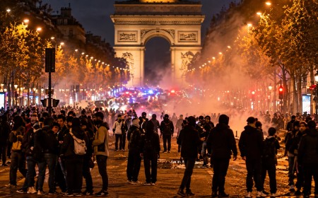 Illustration of crowds and smoke on a Paris avenue at night with the Arc de Triomphe in the background